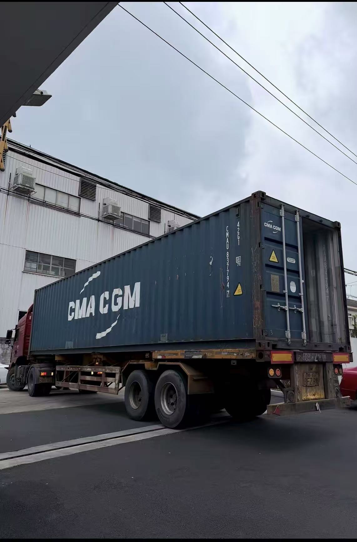 Container truck beside an industrial building