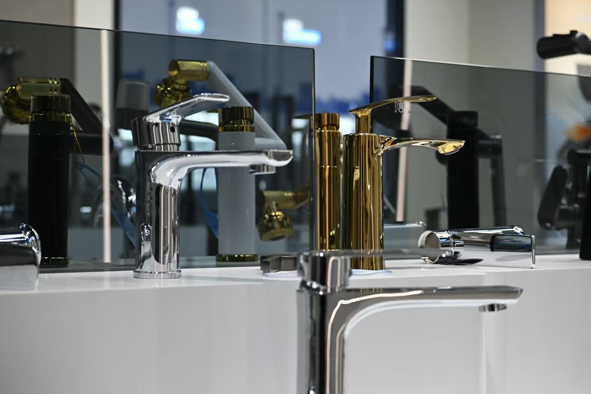 Chrome and gold basin faucets in a product display