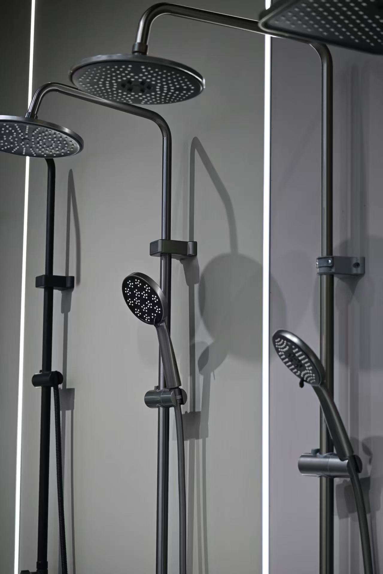 Black shower columns with overhead and hand showers on display